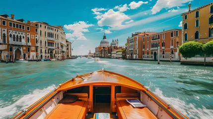 Foto op Canvas This is a photo of a boat on a canal in Venice. The water is a beautiful blue-green color and the sky is bright blue with fluffy white clouds. © Terlan