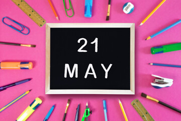 May 21 written in chalk on black board. Calendar date 21th of May on chalkboard on pink blurred...