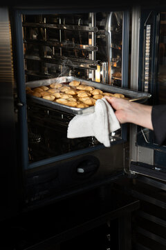 Chef removing food from oven 