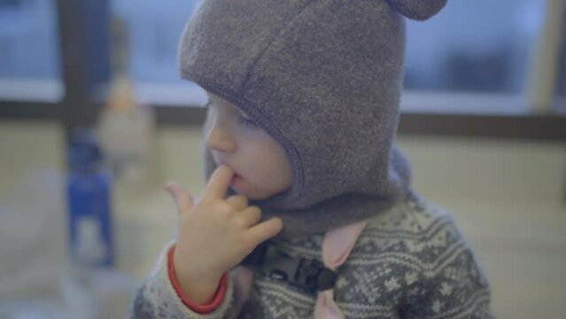 Cute Boy Toddler In Warm Clothing Biting Nails At Home - Fairbanks, Alaska