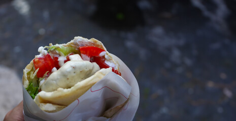 Authentic street food: falafel sandwich with pita bread, hummus, tomatoes, and lettuce - 766546221