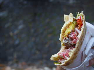 Authentic street food: falafel sandwich with pita bread, hummus, tomatoes, and lettuce - 766546257