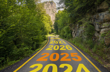 The beginning of the new year 2025. The years 2025 - 2036 written on the road in the middle of the forest.  Concept of New Year plans for travel, exploration and holidays