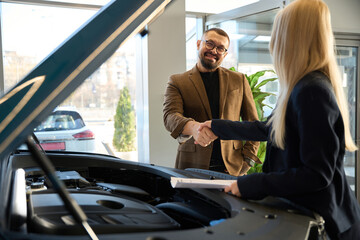 Man shakes hands with a woman salesman