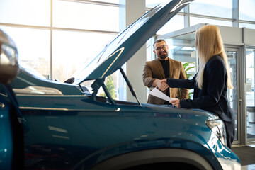 People shaking hands at a car sales point