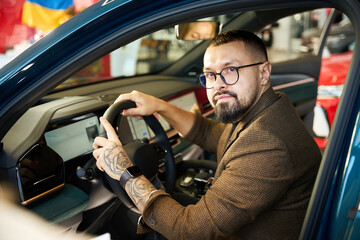 Caucasian man sitting in the interior of a new car