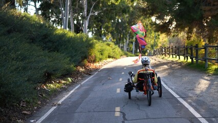 Naklejka premium Rear view of mature woman riding a recumbent electric bike on a bike path in Southern California. Filmed in.