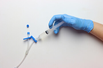 Syringe with drug beeing injected in a 2-ways catheter in a white background 