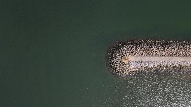 Aerial View of a Breakwater Structure with Tetrapods and a Backhoe Loader