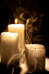 Candles, beautiful candles positioned on dark surface, black background, selective focus.