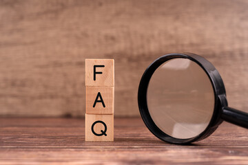 Faq word on wood block and magnifying glass