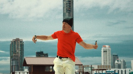 Caucasian hip-hop dancer pose at camera while standing at rooftop with city view. Attractive...
