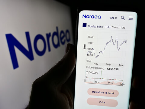Stuttgart, Germany - 03-15-2024: Person holding cellphone with webpage of Finnish financial services company Nordea Bank Abp in front of logo. Focus on center of phone display.