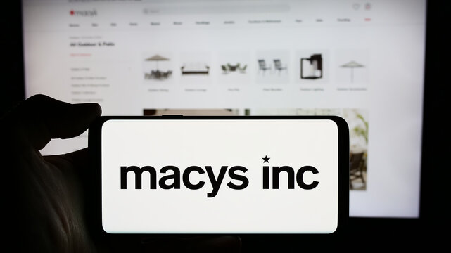 Stuttgart, Germany - 03-16-2024: Person holding cellphone with logo of US department store retail company Macy’s Inc. in front of business webpage. Focus on phone display.