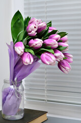 Bouquet of purple tulips on the windowsill