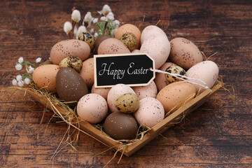 Easter card: Easter basket with Easter eggs in natural tones brown and beige and label with the text Happy Easter.