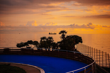 Sunset on the sea. Ship and palm trees on the background of the sea