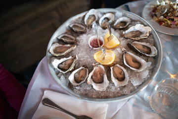 Rock Oysters prepared for sharing in a large dish, in their shell, served on ice with lemon and relish. - 766588055