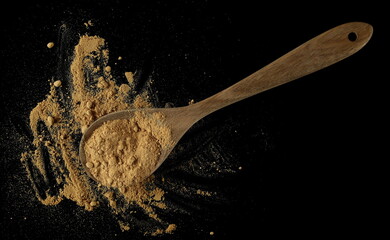 Ginger root powder in wooden spoon, isolated on black, top view, clipping path - 766590095