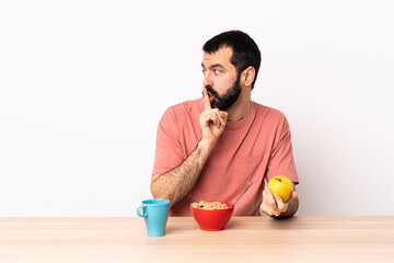 Caucasian man having breakfast in a table showing a sign of silence gesture putting finger in mouth.