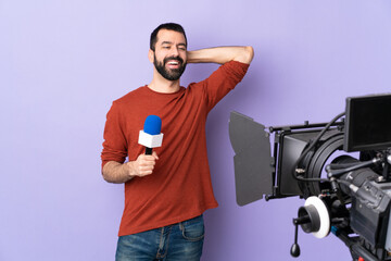 Reporter man holding a microphone and reporting news over isolated purple background laughing - 766590440