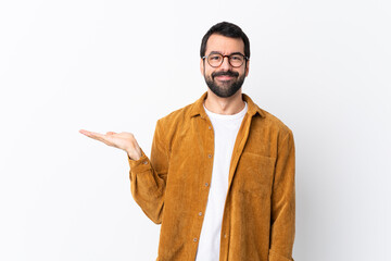 Caucasian handsome man with beard wearing a corduroy jacket over isolated white background holding...