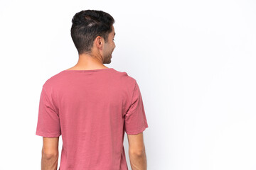 Fototapeta premium Young handsome man over isolated white background in back position and looking side