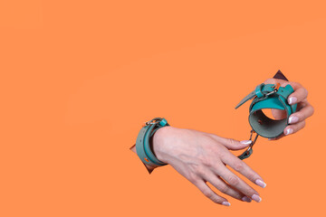 A sex toy. BDSM handcuffs on an orange background. Role-playing games