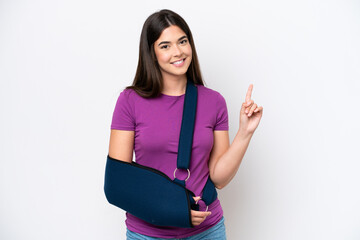 Young Brazilian woman with broken arm and wearing a sling isolated on white background showing and...