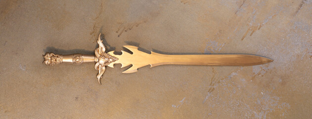 medieval golden sword on old background