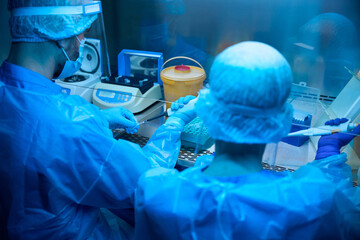 Colleagues, virologists, use a pipette dispenser at work