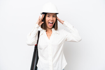 Young architect woman with helmet and holding blueprints isolated on white background with surprise expression