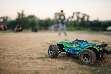 Selective focus on a toy car with people in the blurred background, outdoors.