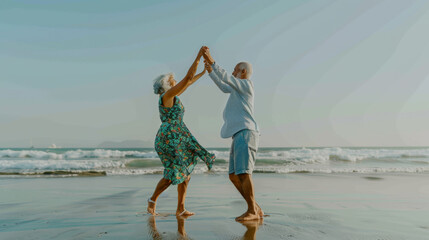 Two seniors dance joyfully on a sandy beach by the sea.