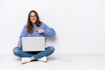 Young caucasian woman with a laptop sitting on the floor isolated on white background with surprise...
