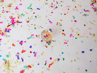 beautiful glass with a drink, around multi-colored paper confetti, party, surprise, on a white background