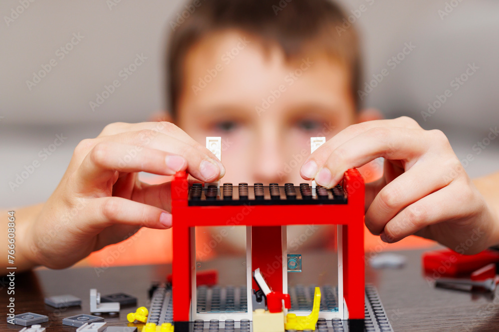 Aufkleber child building a red toy structure with blocks on a table