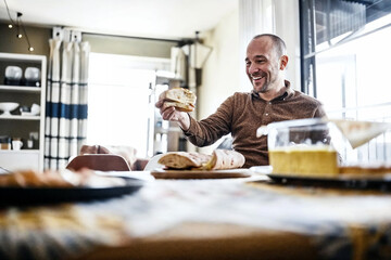 Man relishing his first bite of crusty bread after quitting a keto diet, embodying a joyful carbohydrate craving.