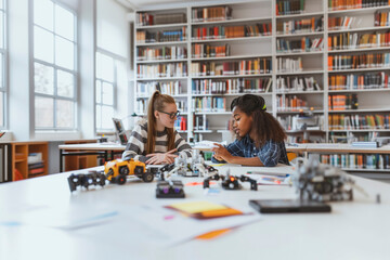 Two students working on robotics in a library.