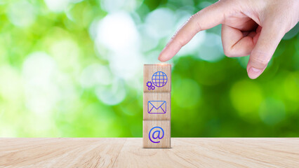 Business hand choose wooden block cube with symbol Global network connection, telephone, Chat, email, address, wifi, Website page contact us or email marketing concept. Digital link tech