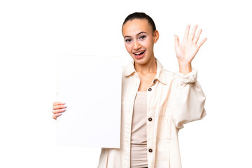 Young Arab woman over isolated background holding an empty placard and saluting