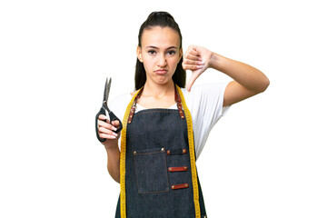 Young Seamstress woman over isolated chroma key background showing thumb down with negative...