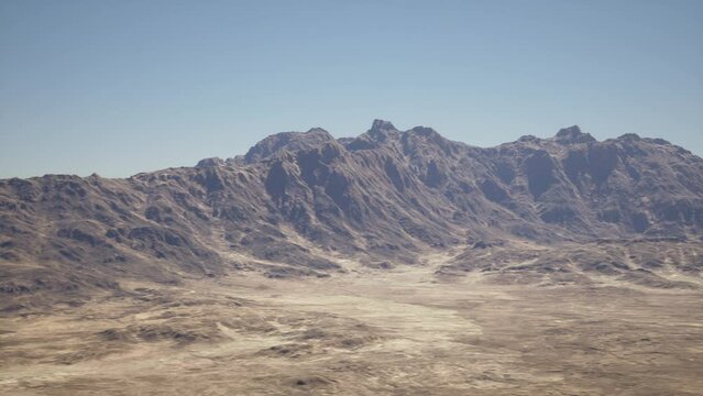 A breathtaking aerial view of a majestic mountain range standing tall amidst a vast desert landscape