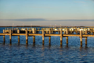 Long wooden dock on a smooth bay during the golden afternoon hour