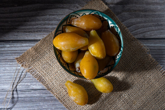 Top view of small, very sweet, yellow plums in a compote bowl.