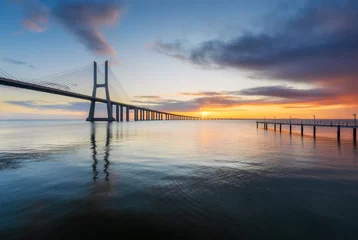 Photo sur Plexiglas Pont Vasco da Gama Vasco da Gama bridge and pier over tagus river in Lisbon (Portugal), at sunrise