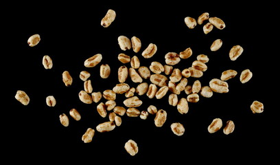 Puffed wheat cereal flakes with honey isolated on black, top view - 766629481