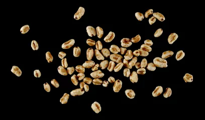 Poster Puffed wheat cereal flakes with honey isolated on black, top view © dule964