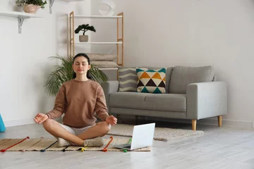 Tuinposter Beautiful woman meditating on mat at home © Pixel-Shot
