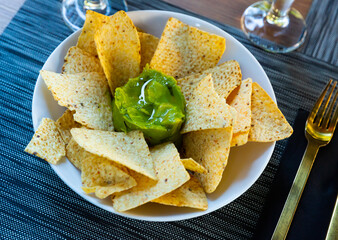 Traditional Mexican Guacamole sauce with savory crispy nachos